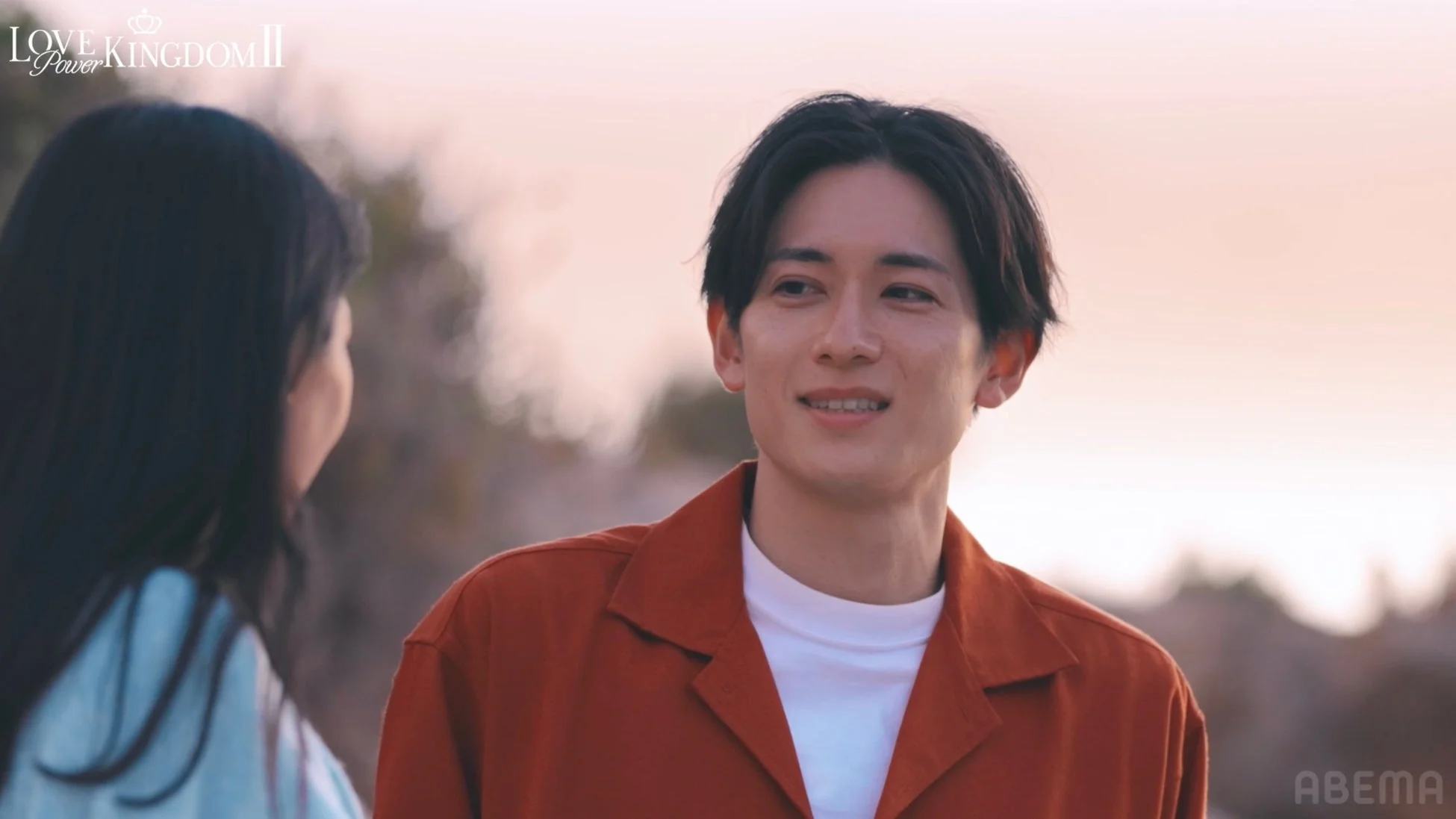 夕焼け空の下、笑顔で見つめ合うカップル