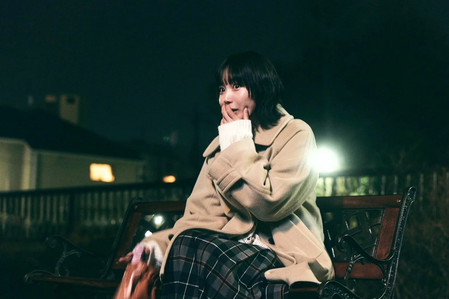 夜のベンチに座る女性