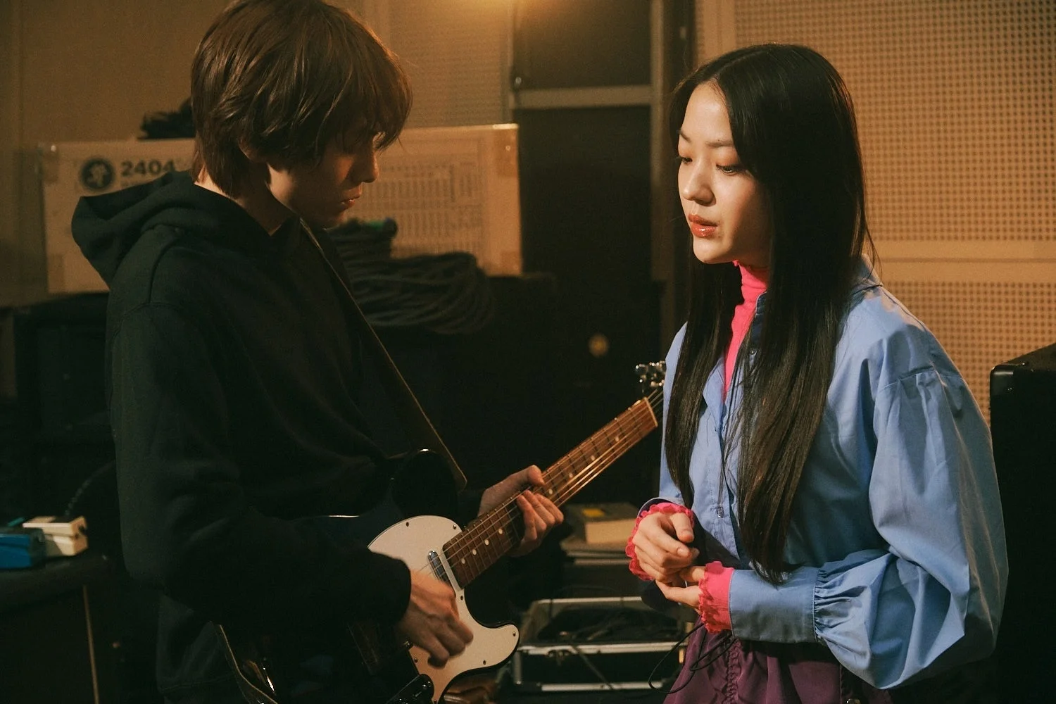スタジオでギターを弾く男性と女性