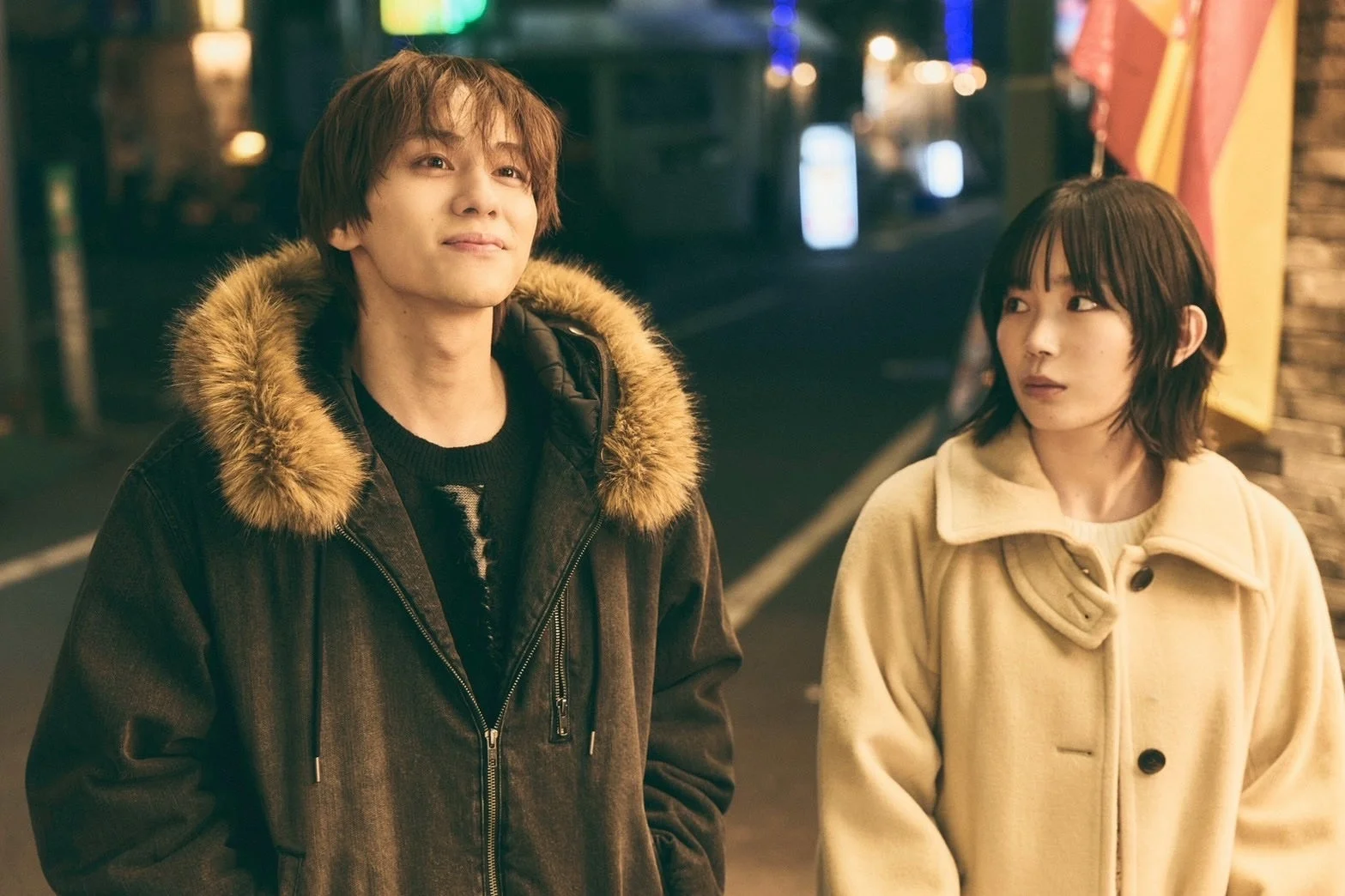 夜の街を歩く若い男女