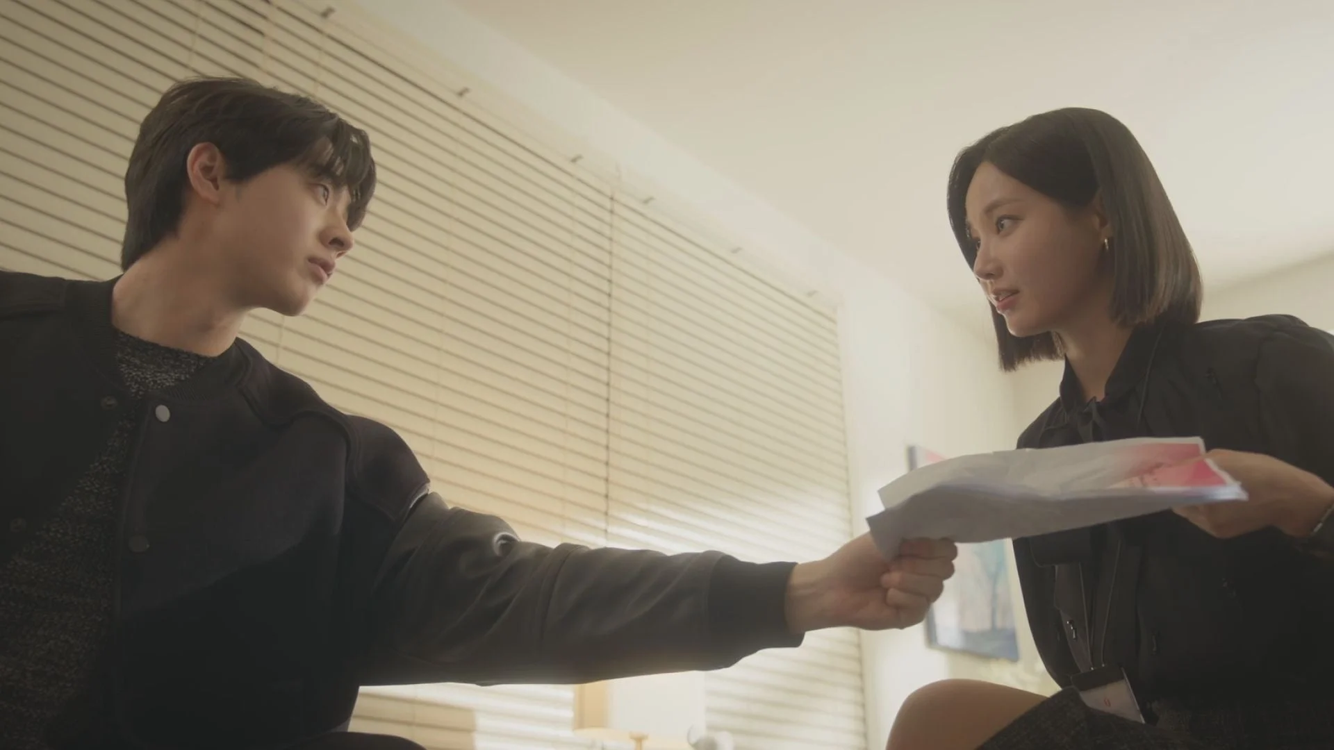 書類の受け渡しをする男女