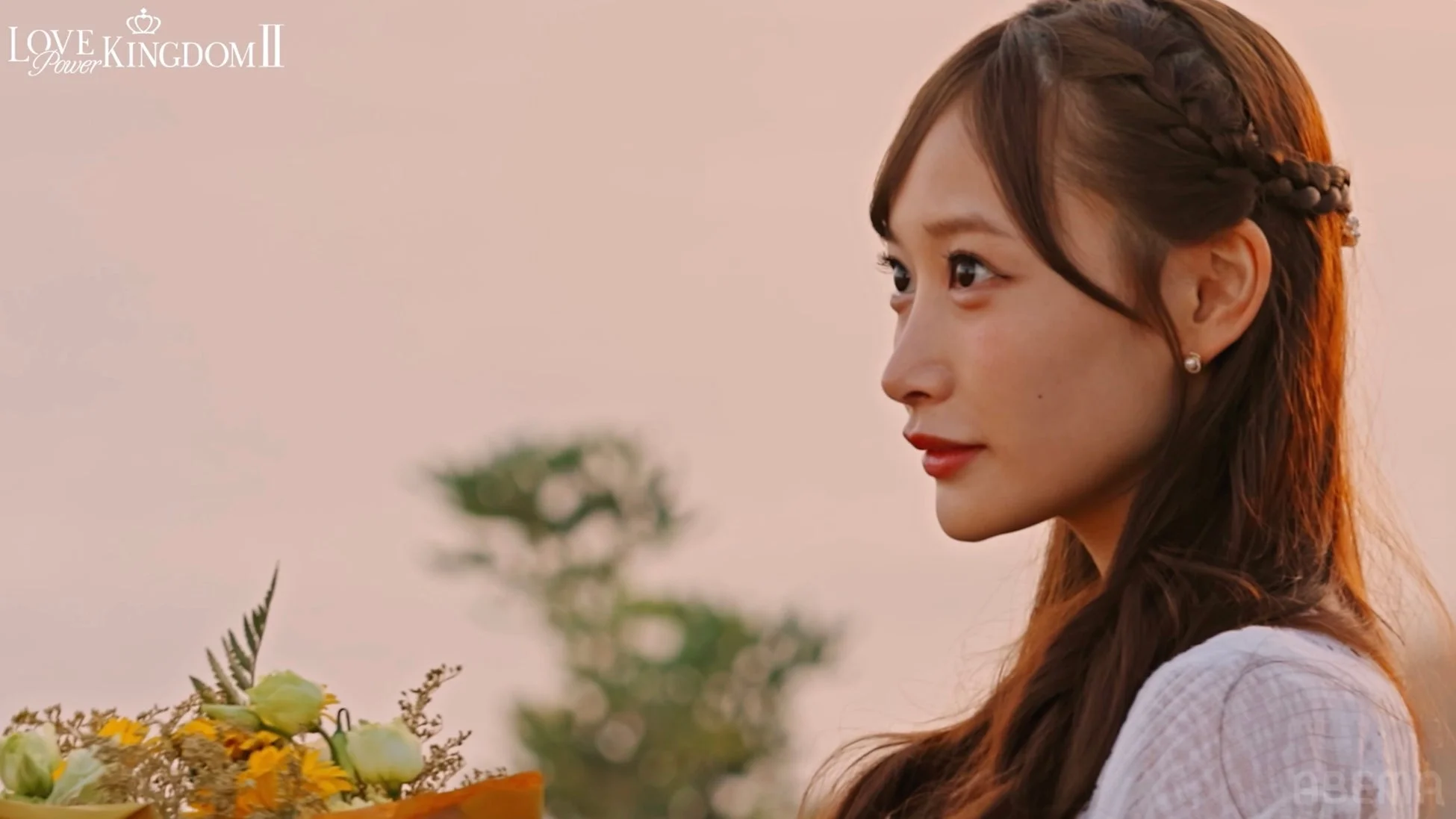 夕焼け空の下、花束を手に遠くを見つめる女性