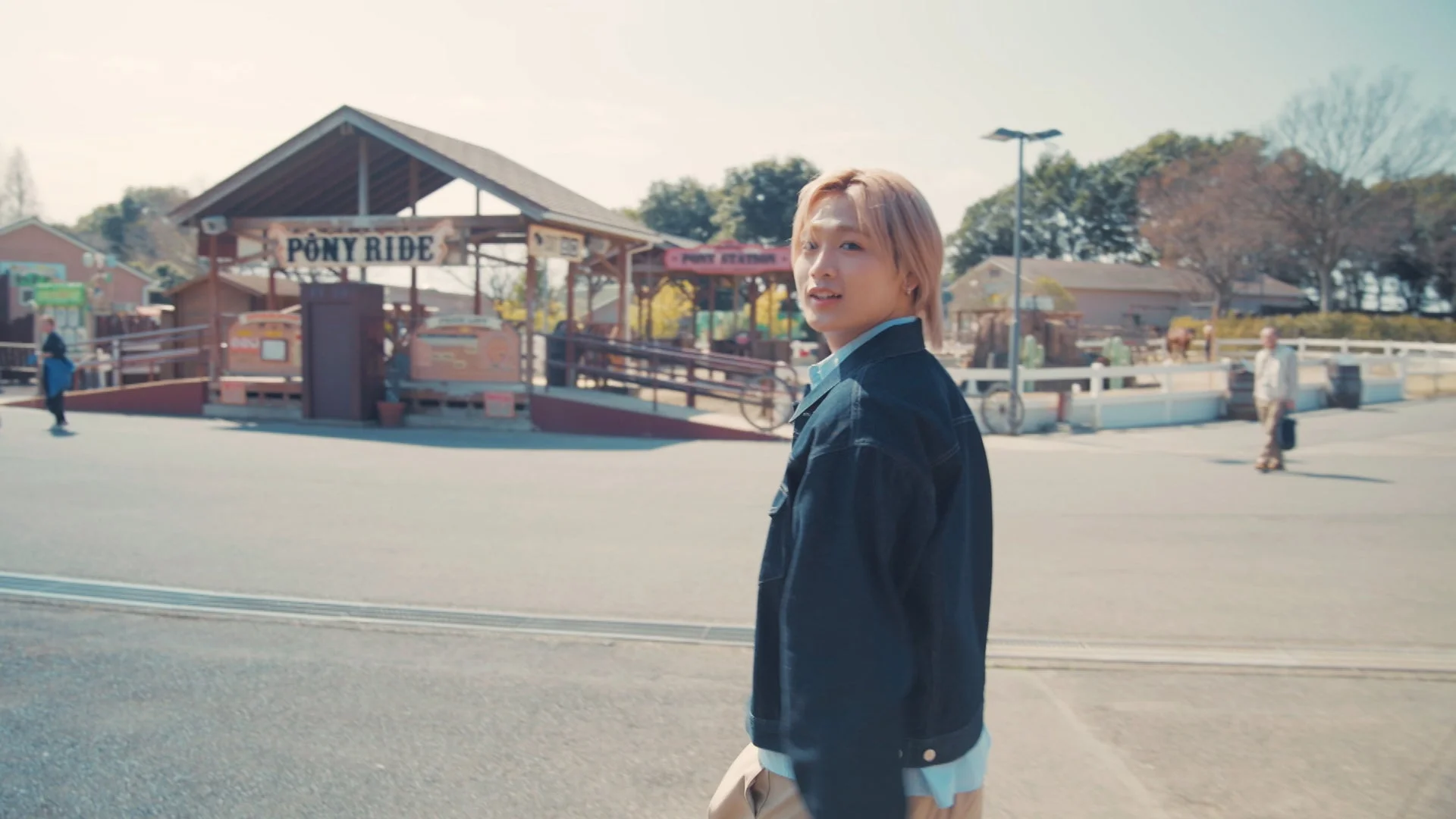 田中笑太郎がPONY RIDEの看板の前で振り返る