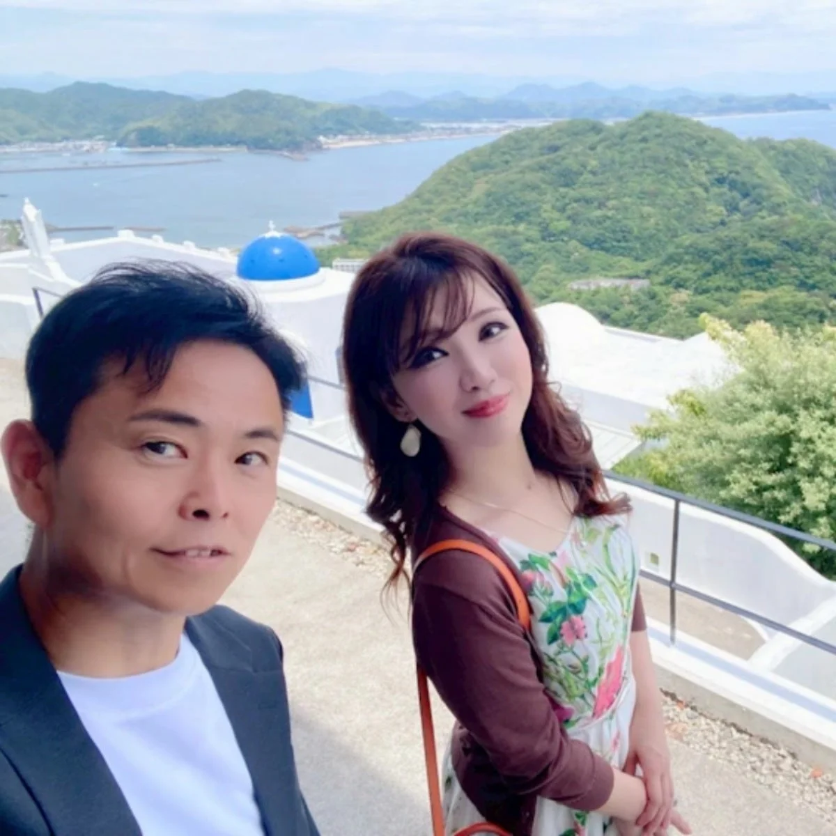 絶景を背景に笑顔でセルフィーを撮るカップル