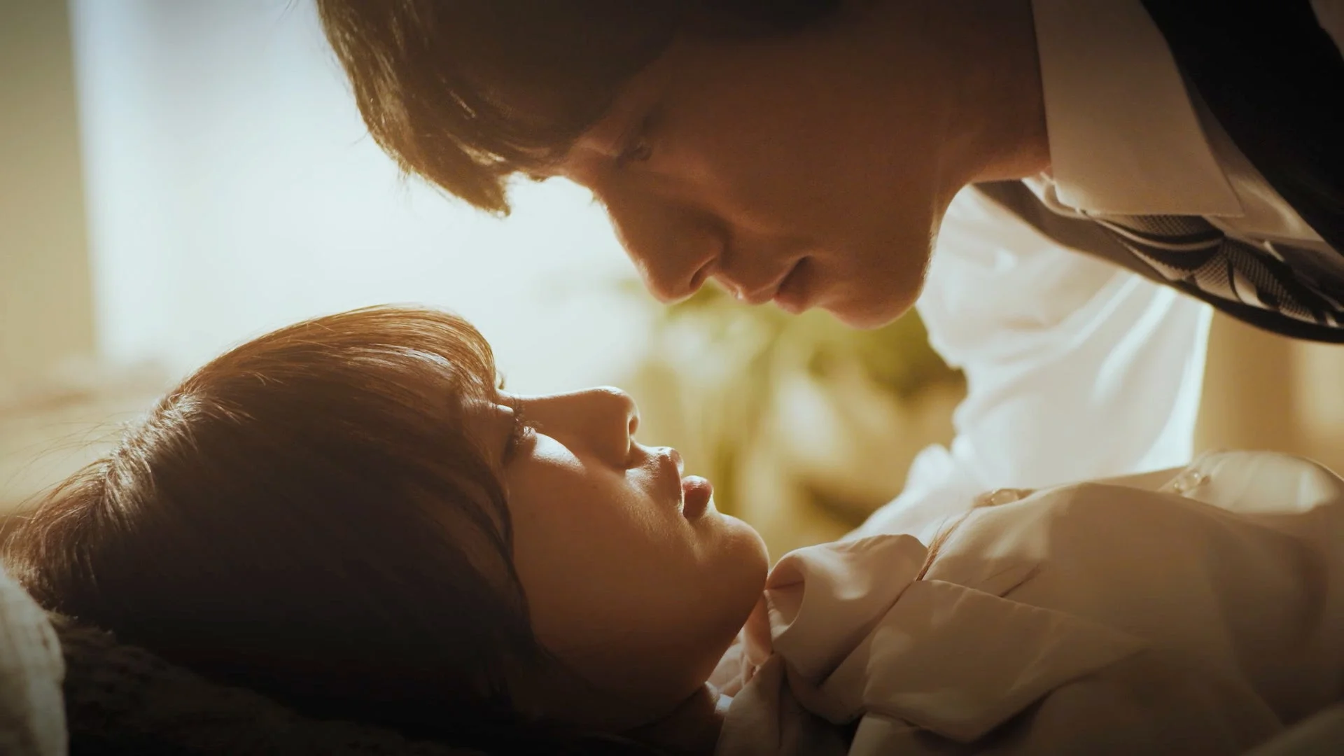 暖かな光の中で男性が女性に顔を近づけ見つめ合う