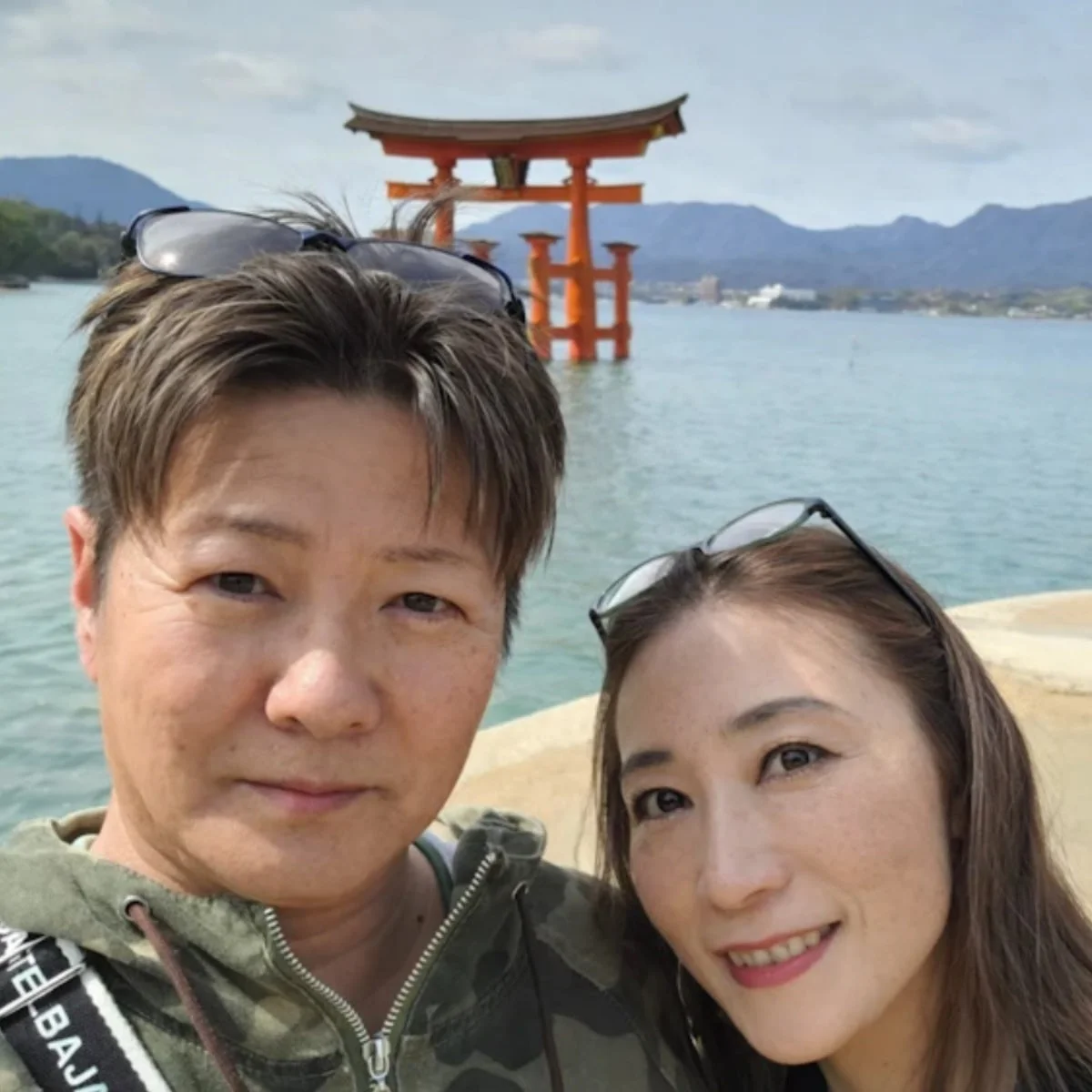 厳島神社を背景に笑顔で写るカップル