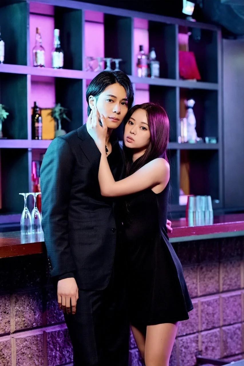 紫色の照明のバーでの親密なカップル