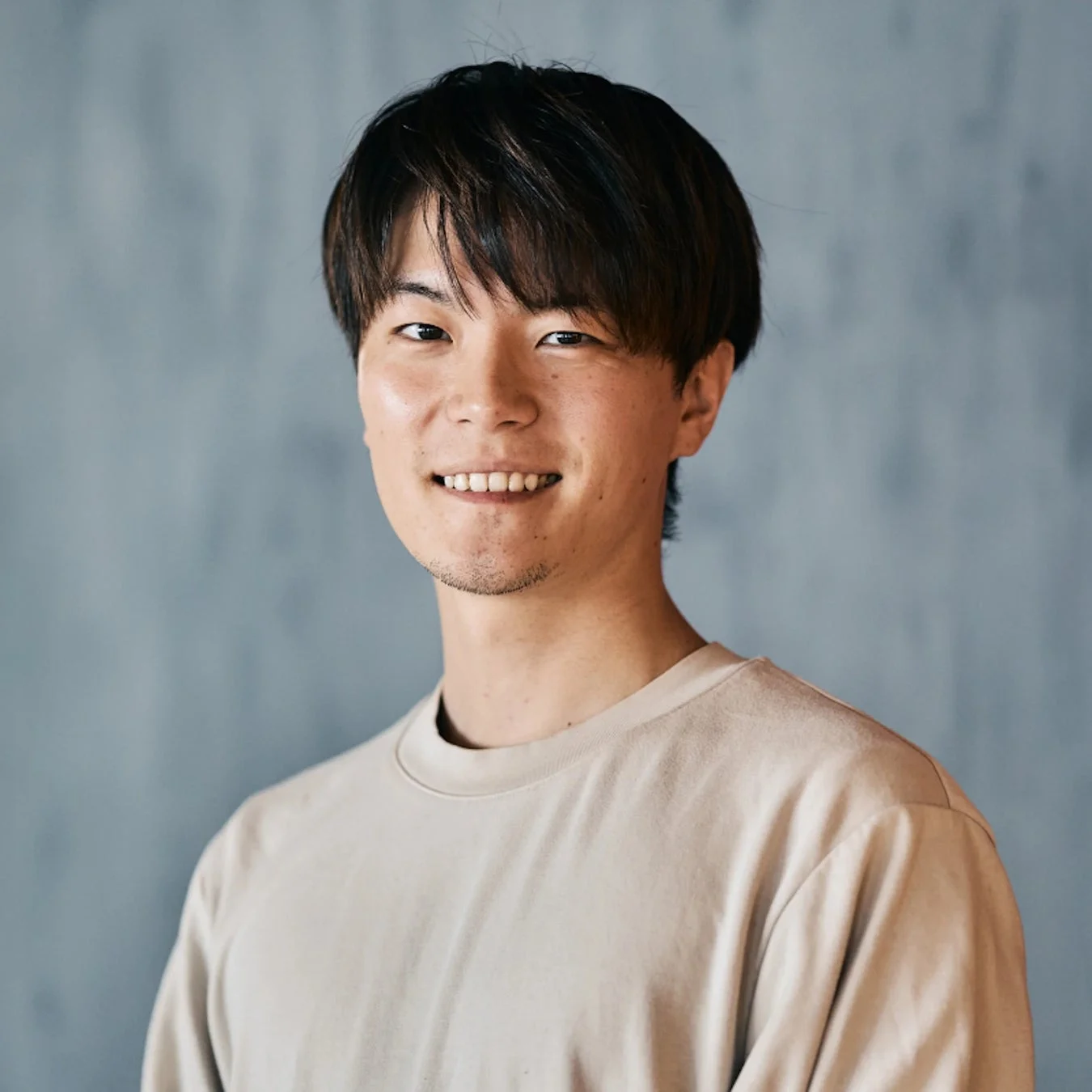 笑顔でこちらを見つめる若い男性のポートレート