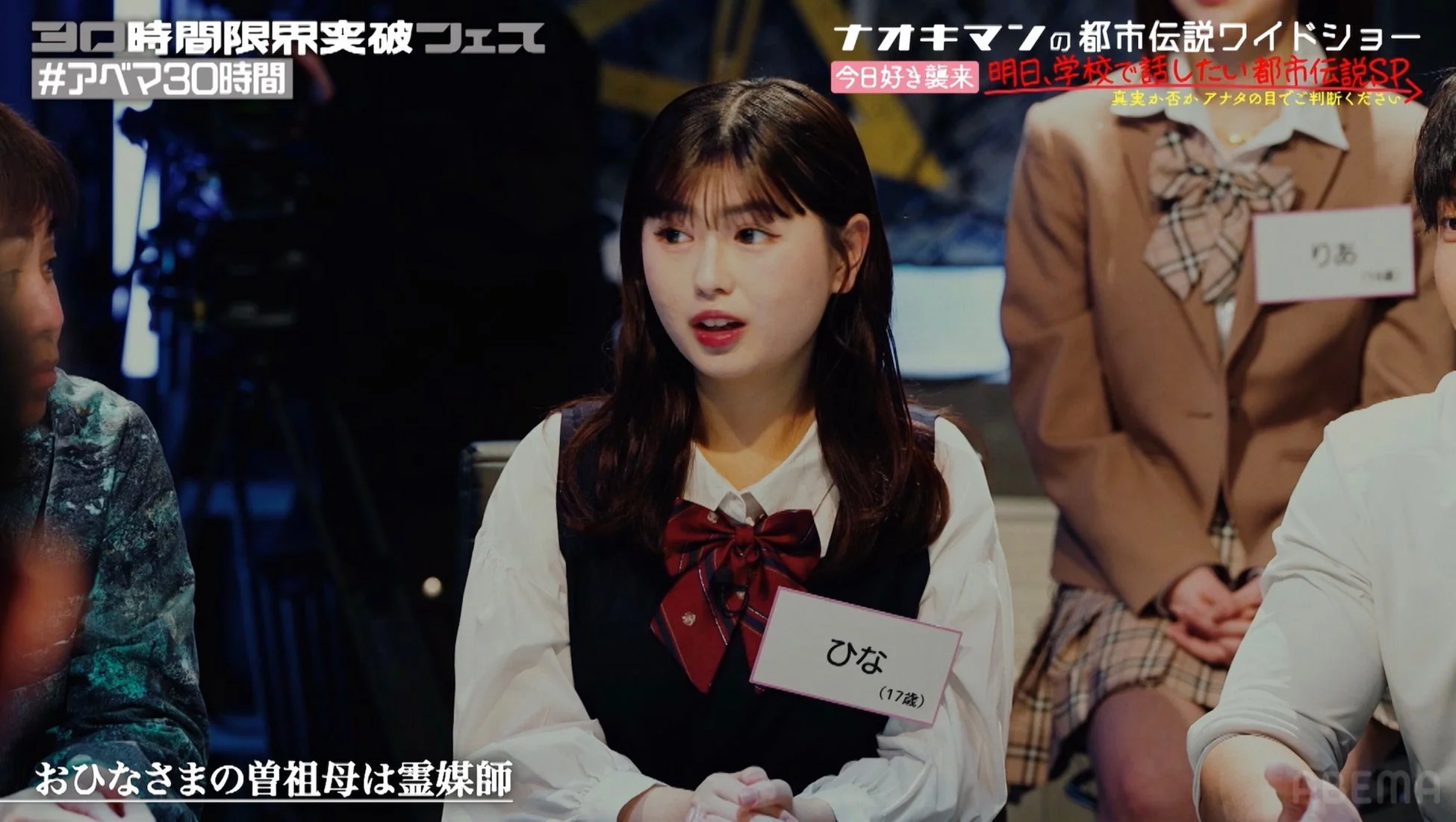 若者向けのバラエティ番組で、女子高生らしき出演者が都市伝説をテーマにトークしている場面。画面上部には番組タイトルとテーマ、下部には「おひなさまの曽祖母は霊媒師」というテロップが表示されている。