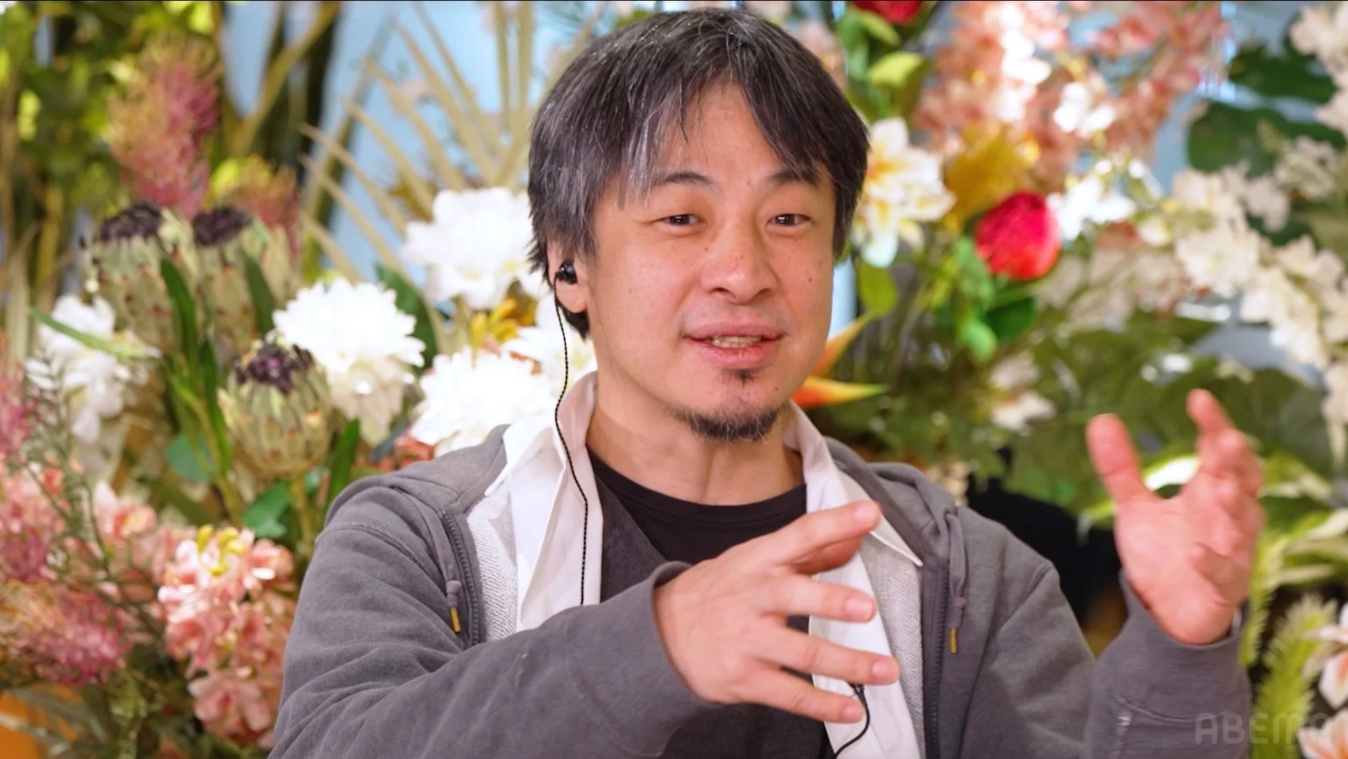 花を背景に話す石丸伸二